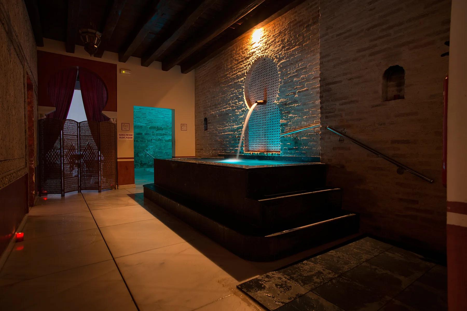 Cascada nocturna en sala morisca con piscina caliente