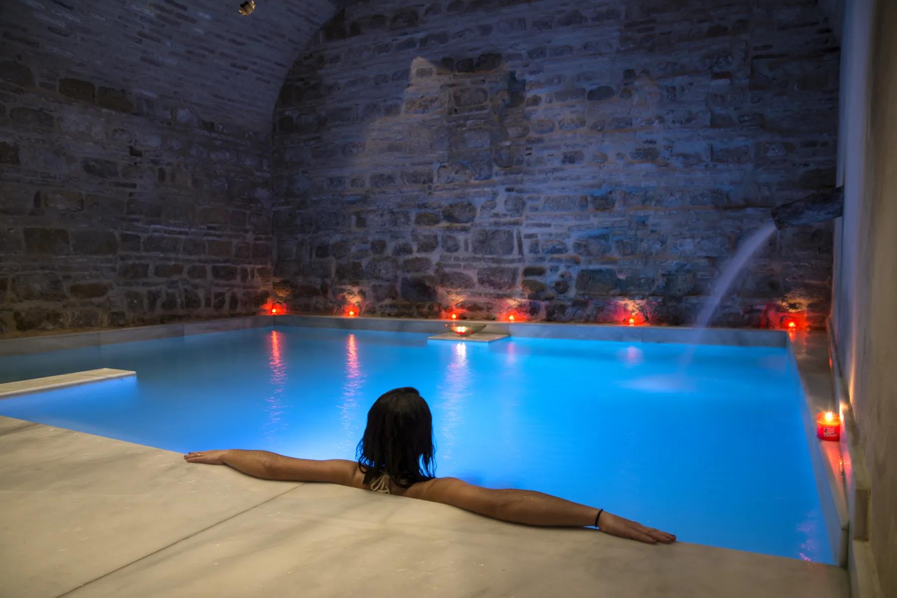 Persona flotando en piscina turquesa con velas