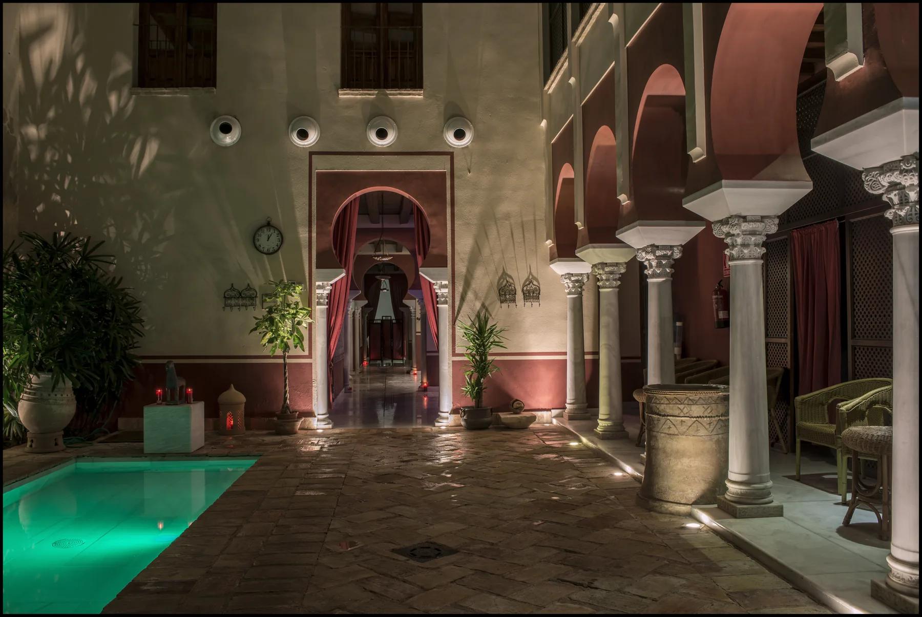 Patio interior nocturno con columnata califal en los Baños Árabes